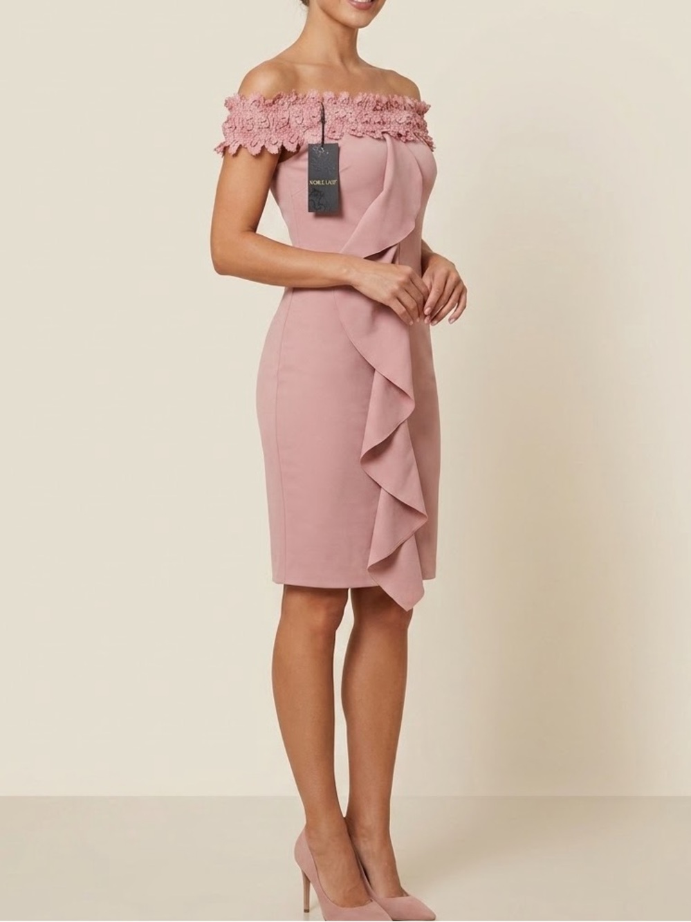 This is a dusty pink off-the-shoulder dress featuring a cascading front ruffle a